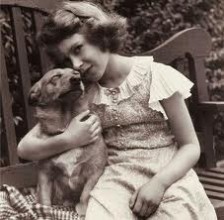 A young Elizabeth shows her early love of Corgies, here holding her pet, Dookie.
